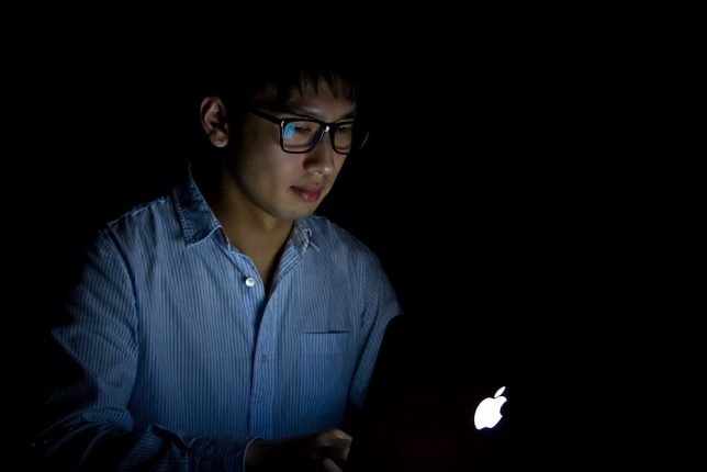 暗闇でパソコンを触る男性
