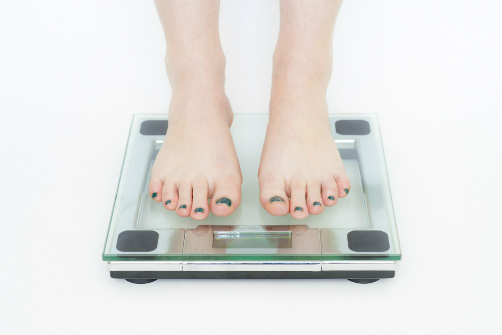 ダイエットで体重計に乗る女性の脚